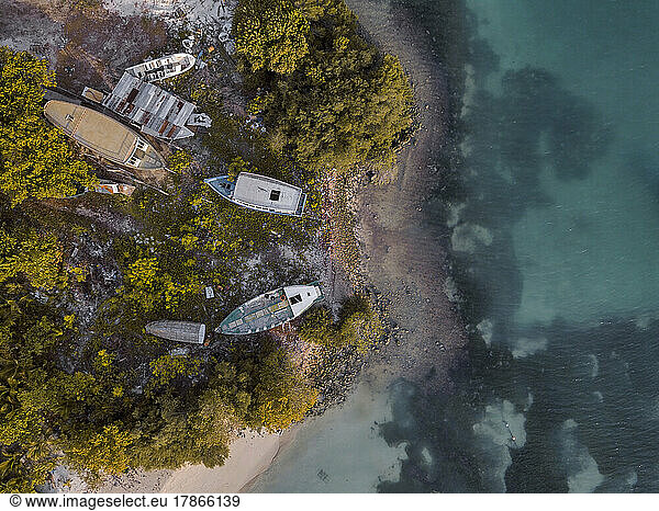 Aerial view of old boats abandoned on coastal beach