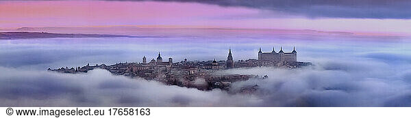 Aerial view of old city shrouded in mist at colorful sunrise