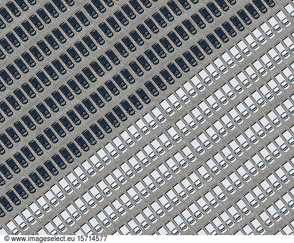 Aerial view of parking lot filled with black and white cars