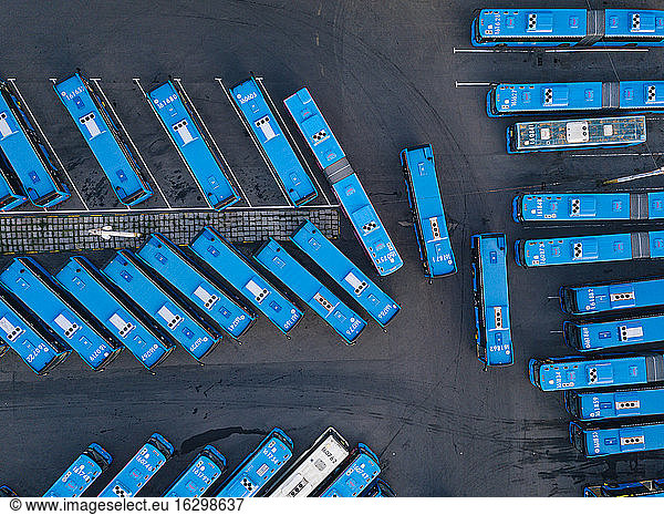 Aerial view of parking lot filled with blue buses