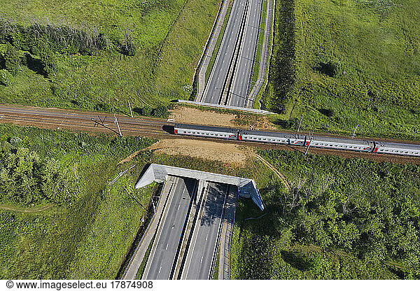 Aerial view of passenger train passing across railroad overpass