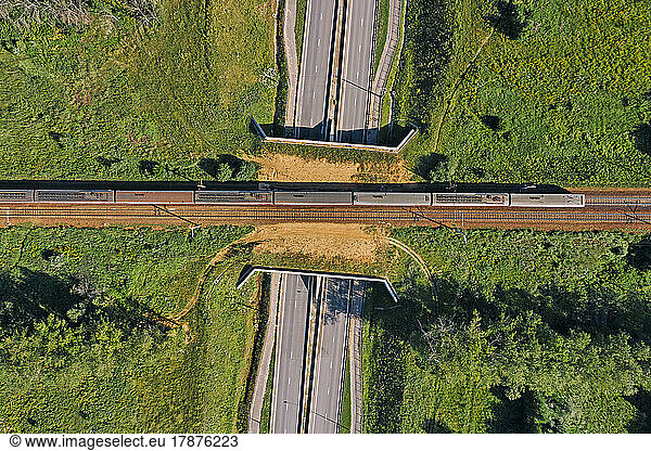 Aerial view of passenger train passing across railroad overpass