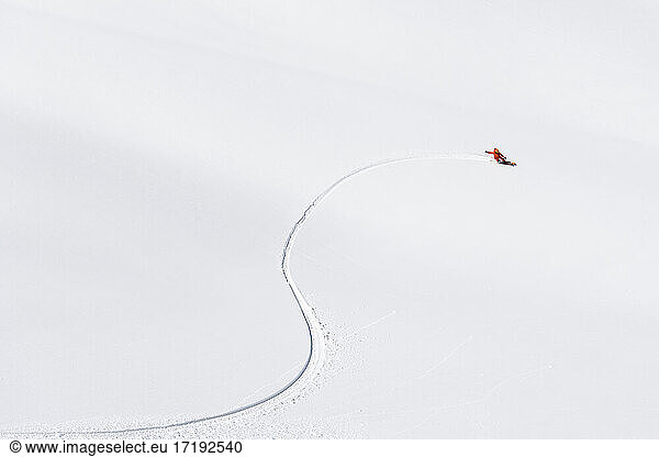 Aerial view of person snowboarding on snowcapped mountain during vacation