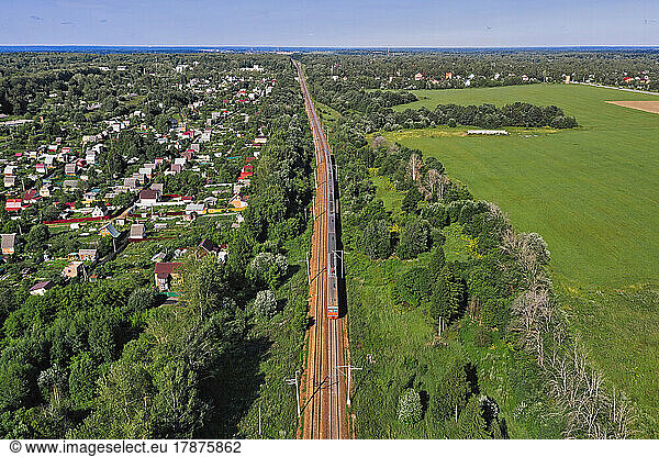 Aerial view of railroad tracks stretching along edge of rural town