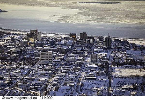 Aerial view of 3rd  4th  5th and 6th avenues running West towards the ocean through downtown Anchorage  sea ice on Cook Inlet in the background  the Marriot  Hilton and Captain Cook Hotels visible in the foreground  South-central Alaska; Anchorage  Alaska  United States of America