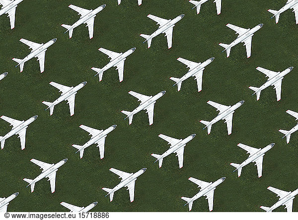 Aerial view of rows of airplanes standing on green grass