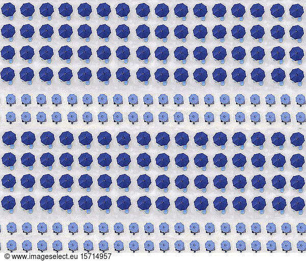Aerial view of rows of blue beach umbrellas