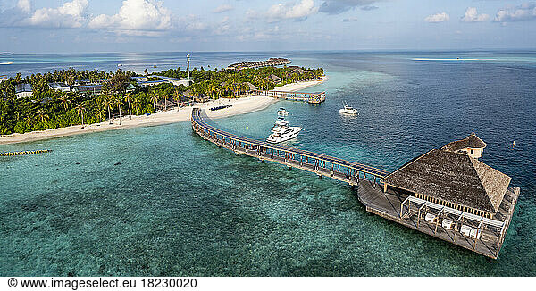 Aerial view of sea with tourist resort under cloudy sky at Maldives