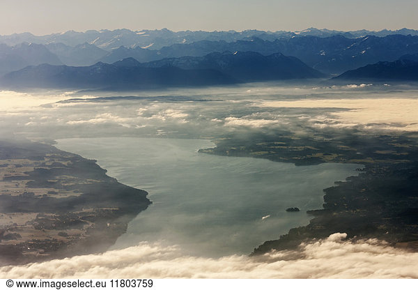 Aerial view of silhouetted mountain range by river with landscape and clouds