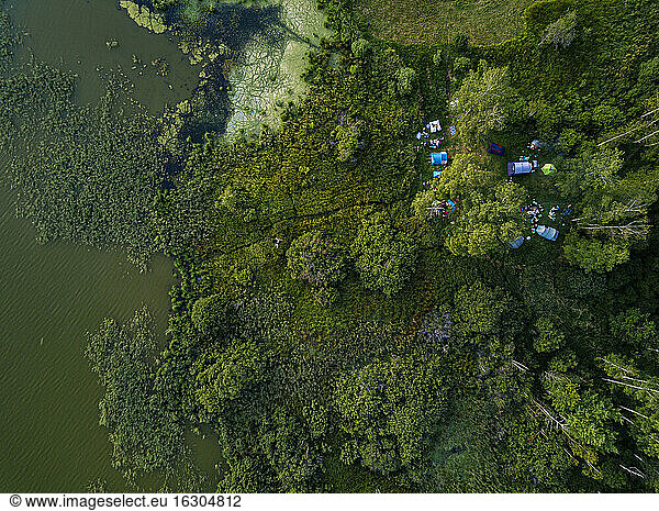 Aerial view of tents pitched on green shore of Torbeyevskoye lake