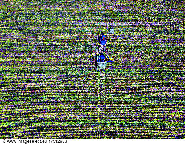 Aerial view of tractor collecting hay bales in field