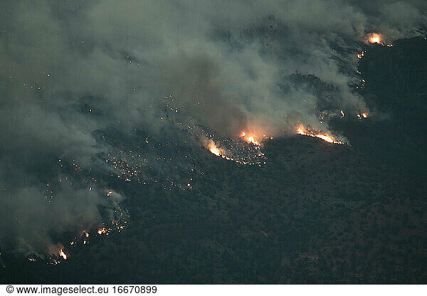 Aerial view of wildfire in forest at dusk