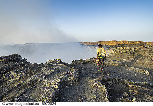 Afar man looking down to Erta Ale volcano caldera  Danakil Depression  Afar Region  Ethiopia  Africa