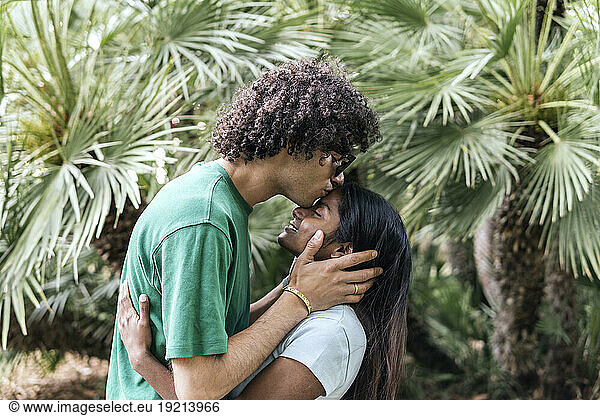 Affectionate boyfriend kissing girlfriend in park