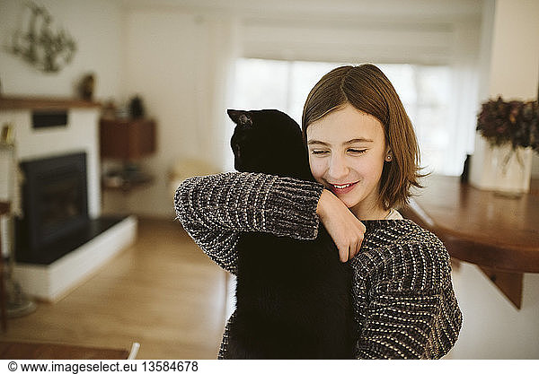 Affectionate girl holding black cat