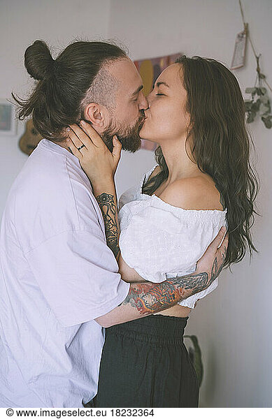 Affectionate hipster couple kissing each other