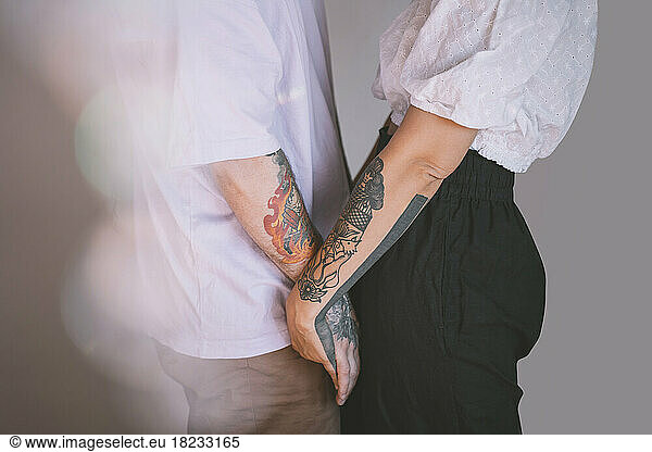 Affectionate hipster couple with hands clasped