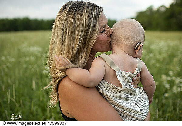 Affectionate mother with eyes closed kissing son at garden