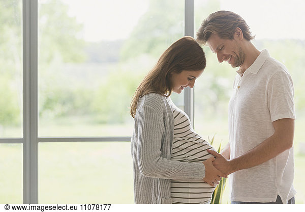 Affectionate pregnant couple touching stomach