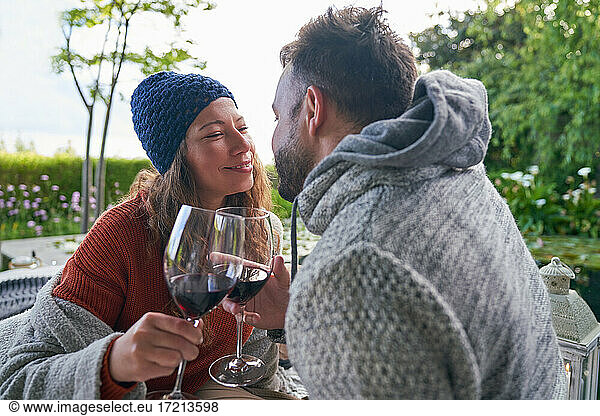 Affectionate romantic couple drinking red wine on patio