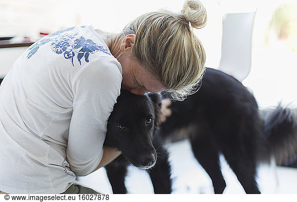 Affectionate woman hugging dog