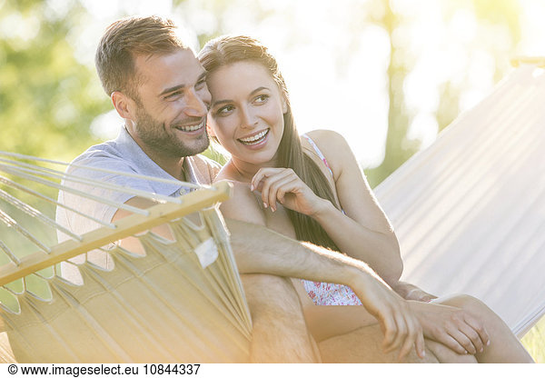 Affectionate young couple smiling in summer hammock