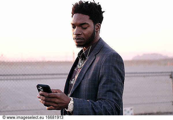 African American Business Man Checking Phone At Sunset