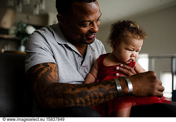 African American Dad Holding Mixed Race Daughter