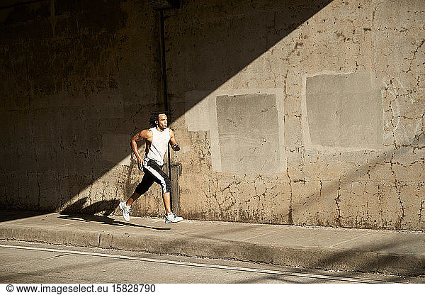 African-American man running on sidewalk