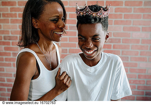 African-American mom laughing with son wearing tiara