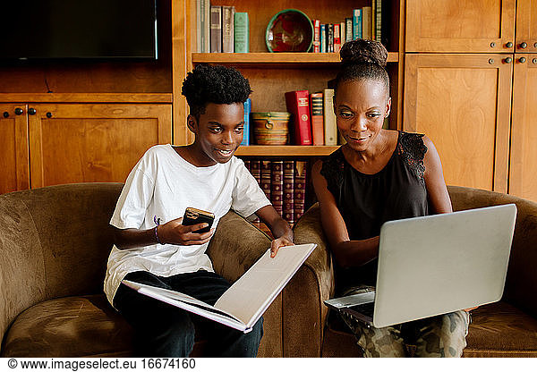 African American mom with laptop helps son during distance learning