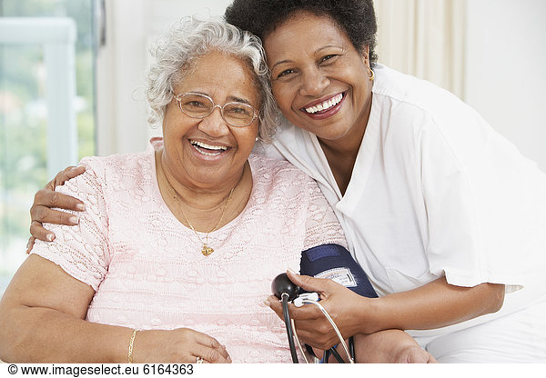 African American mother and adult daughter smiling at each other