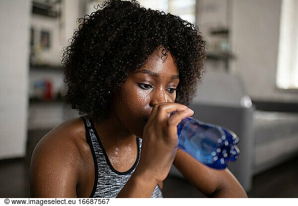 African American sportswoman drinking water