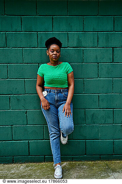 African american woman posing on green wall