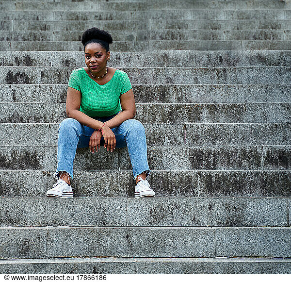 african american woman sitting on stairs smiling