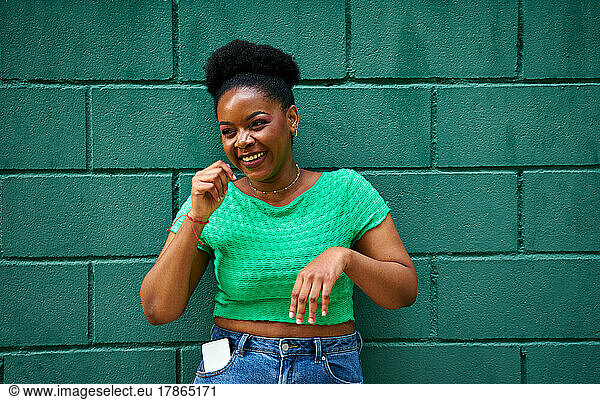 African american woman smiling on green wall