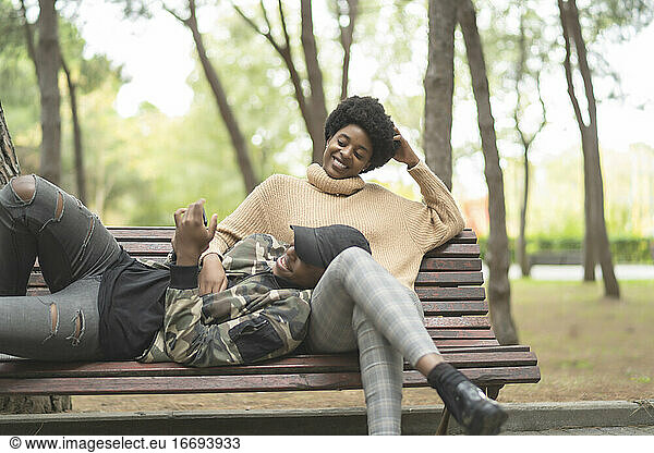 african couple in love lying on the park bench