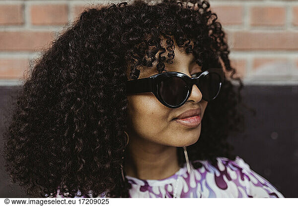 African teenage girl with sunglasses looking away outdoors