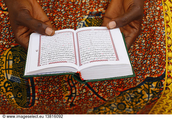 Afrikanische Frau liest den Koran.