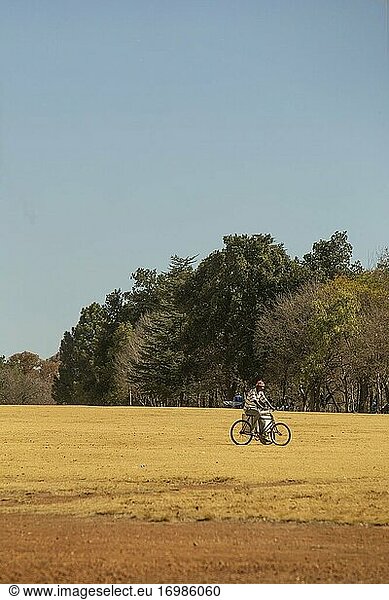 Afrikanischer Mann beim Radfahren am Emmarentia-Damm  Johannesburg  Südafrika