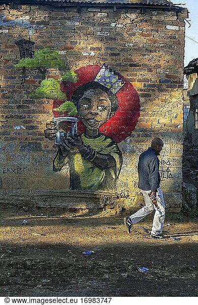 Afrikanischer Mann geht an einem Graffiti im Township Diepsloot  Johannesburg  Südafrika  vorbei