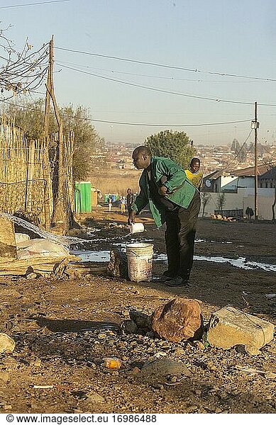 Afrikanischer Mann wirft Waschwasser  Diepsloot Township  Johannesburg  Südafrika