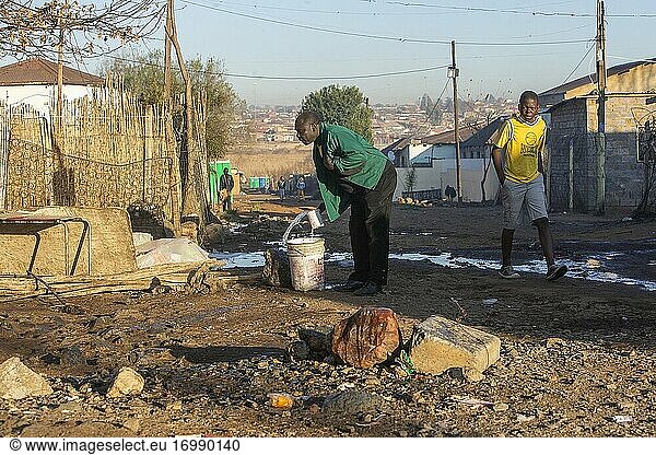 Afrikanischer Mann wirft Waschwasser  Diepsloot Township  Johannesburg  Südafrika