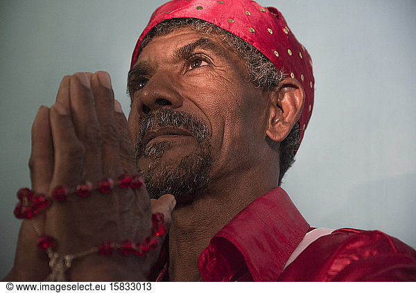 Afro-brasilianischer Mann betet während religiöser Karnevalsfeier