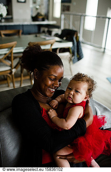 Afroamerikanische Schwester hält gemischtrassige Baby-Schwester