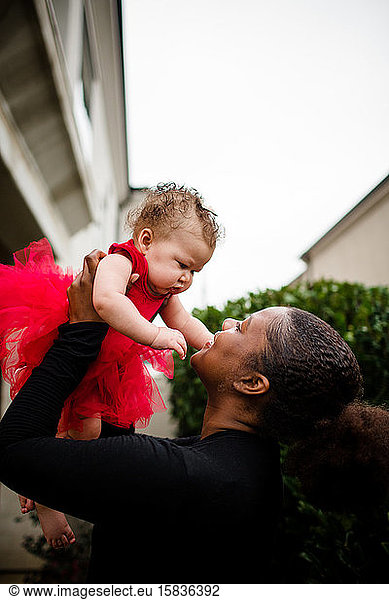 Afroamerikanische Stiefschwester hält bi-rassische Baby-Schwester