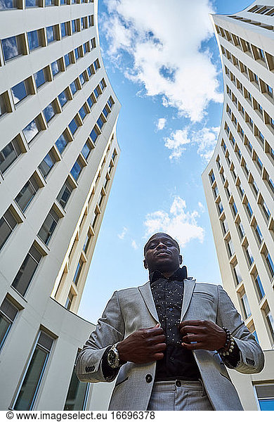 Afroamerikanischer Geschäftsmann zwischen Gebäuden.