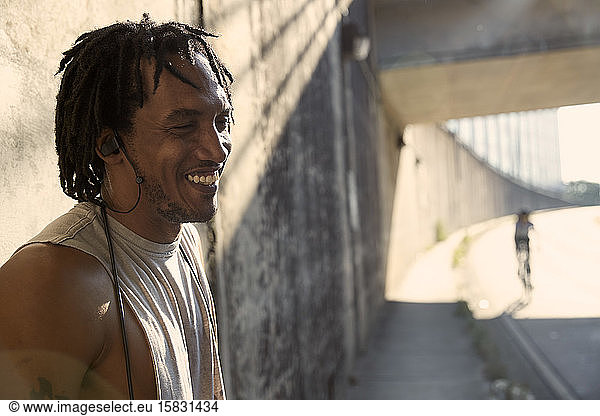 Afroamerikanischer lachender Mann mit Ohrstöpseln