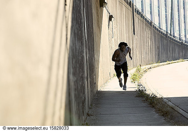 Afroamerikanischer Mann rennt auf Bürgersteig