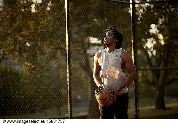 Afroamerikanischer Mann spielt Basketball im Freien